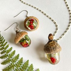 two necklaces and earring sets made out of glass bottles with plants inside them