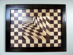 a wooden wall hanging with a checkerboard design on the inside and bottom half