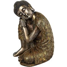 a bronze buddha statue sitting on the ground with his hands clasped to his chest and eyes closed