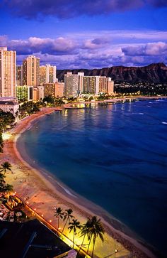 an aerial view of waikiki beach and the city lights at dusk, oahulua