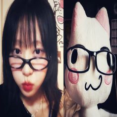 a girl with glasses and a cat stuffed animal in front of her, both looking at the camera