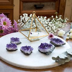 amethysts and flowers on a table next to a candle