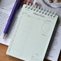 a spiral bound planner sitting on top of a wooden table