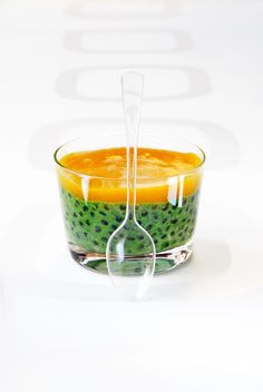 a glass bowl filled with fruit and a spoon