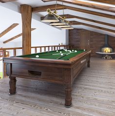 a pool table in the middle of a room with wood floors and exposed ceiling beams