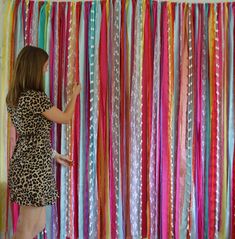 a woman standing next to a wall covered in streamers