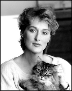 a black and white photo of a woman holding a cat