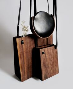 a wooden sculpture with two bags and a round object on it's back side