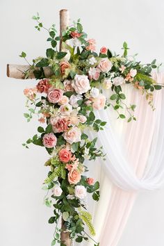 a cross decorated with flowers and greenery