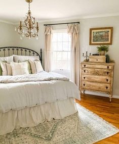 a bedroom with a bed, dresser and chandelier