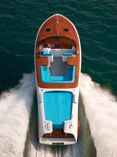 an orange and white boat traveling on the water with its seats up to four people