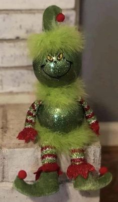 a green and red stuffed animal sitting on top of a table