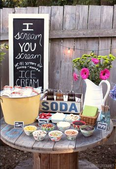 a table with ice cream and desserts on it in front of a sign that says i scream you scream