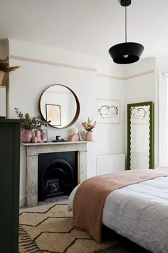 a bedroom with a bed, mirror and fireplace