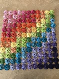 several different colors of paper flowers on a table