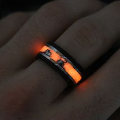 a man's hand with a glowing ring in the shape of an elephant on it