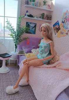 a doll sitting on top of a bed next to a window