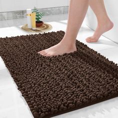 a person walking across a bathroom rug on the floor