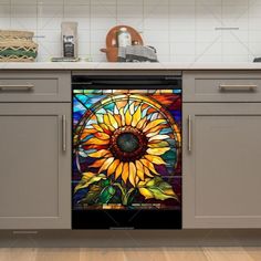 a sunflower stained glass window in the middle of a kitchen cabinet door with stainless steel handles