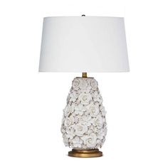 a white lamp with flowers on the base and a white lampshade next to it