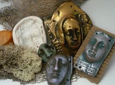 several masks are sitting on top of some fabric and other things in front of them