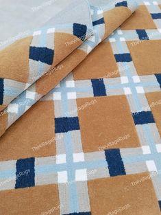 an orange and blue checkered fabric on the ground with white background, it is very soft