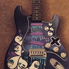 an electric guitar with cartoon characters painted on it