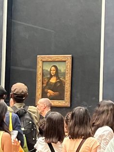 a group of people standing in front of a painting