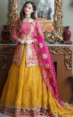 a woman in a yellow and pink lehenga