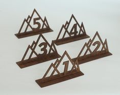 four wooden numbers are placed in the shape of trianglees with one number on each side