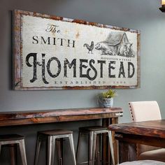 a sign that says the smith homestead hangs above a table with stools in front of it