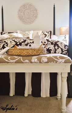 a white bed with black and white comforter