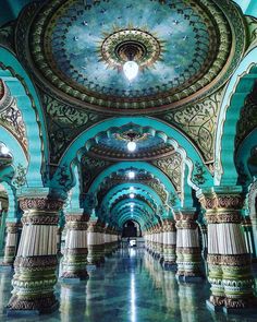 the inside of an ornate building with columns and ceiling lights on either side of it