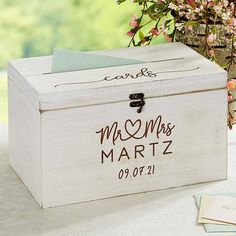 a personalized wooden box sitting on top of a table next to a vase filled with flowers