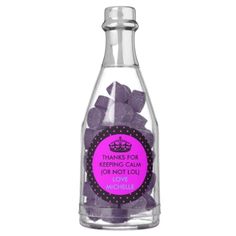 a bottle filled with purple candies sitting on top of a table