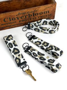 four leopard print key fobs and an old wooden box