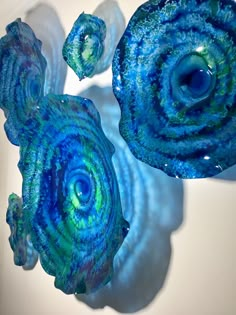 three blue and green swirls are on display