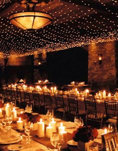 a long table is set with candles and place settings for an event or wedding reception