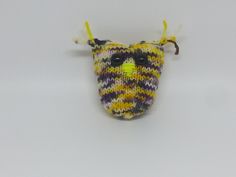 a knitted animal head with horns and eyes on a white tablecloth covered surface