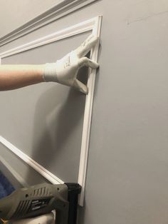 a person using a power drill to paint a door