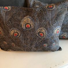 two decorative pillows sitting on top of a table