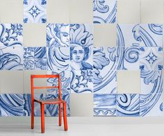 an orange chair sitting in front of a blue and white wall with designs on it