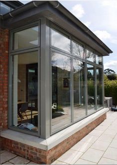 an image of a house that is being built with glass walls and brick pillars on the outside