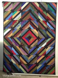 a colorful quilt hanging on the wall