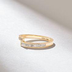 a gold ring with two princess cut diamonds on the side, and an inscription that says dad