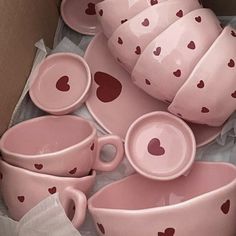 a box filled with lots of pink cups and saucers covered in heart print on them