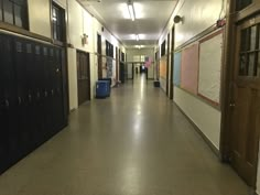 an empty hallway with lockers on both sides and doors to the other side that lead into another room