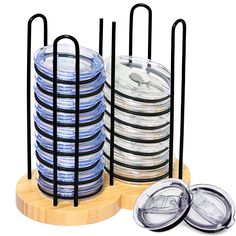 a stack of clear and black discs on a wooden stand with two lids in front of it