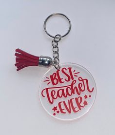 a red and white keychain with the words best teacher ever written on it