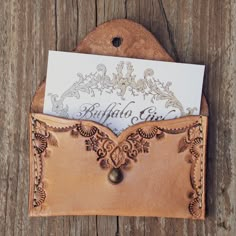 a leather card holder with a note inside on a wooden surface, holding a letter and envelope